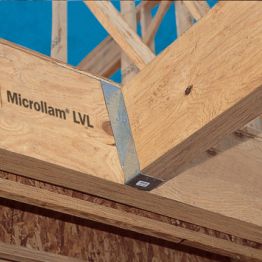 A Microllam LVL beam stamped with the Microllam brand, framing a roof corner with a metal connector