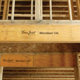 Microllam LVL beams in a wood frame, the thin stacked veneer sheets visible as fine horizontal lines along the edge
