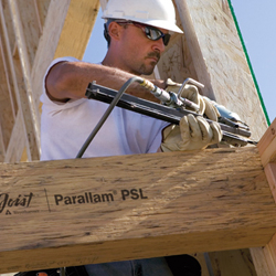 A Parallam PSL beam being installed, its surface showing the long parallel wood strands pressed together